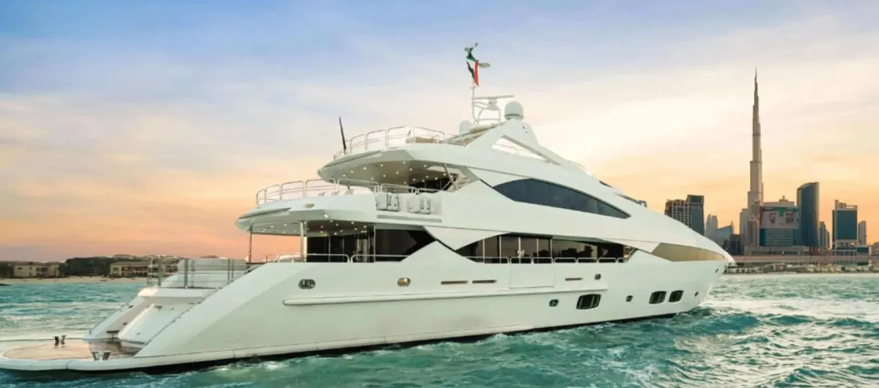 An Elite Pearl Charter motor yacht cruising past the Dubai skyline at sunset