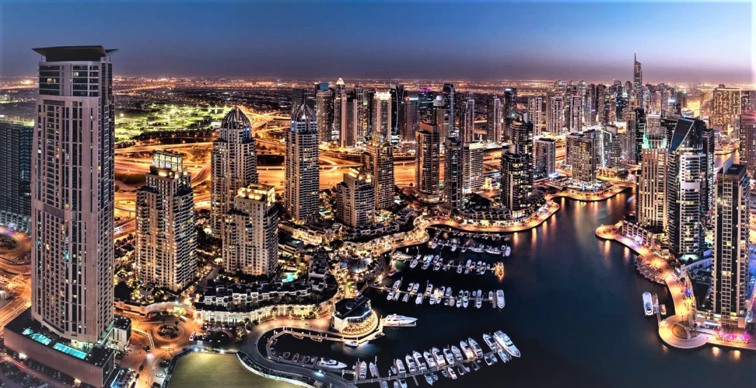 Dubai Marina’s skyline and harbour lit up at dusk