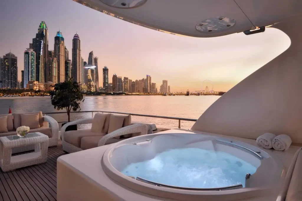 elite pearl charter - a view of dubai within a yacht with jacuzzi during dusk.